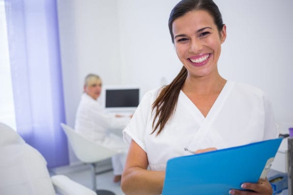 Dental professional holding a medical chart
